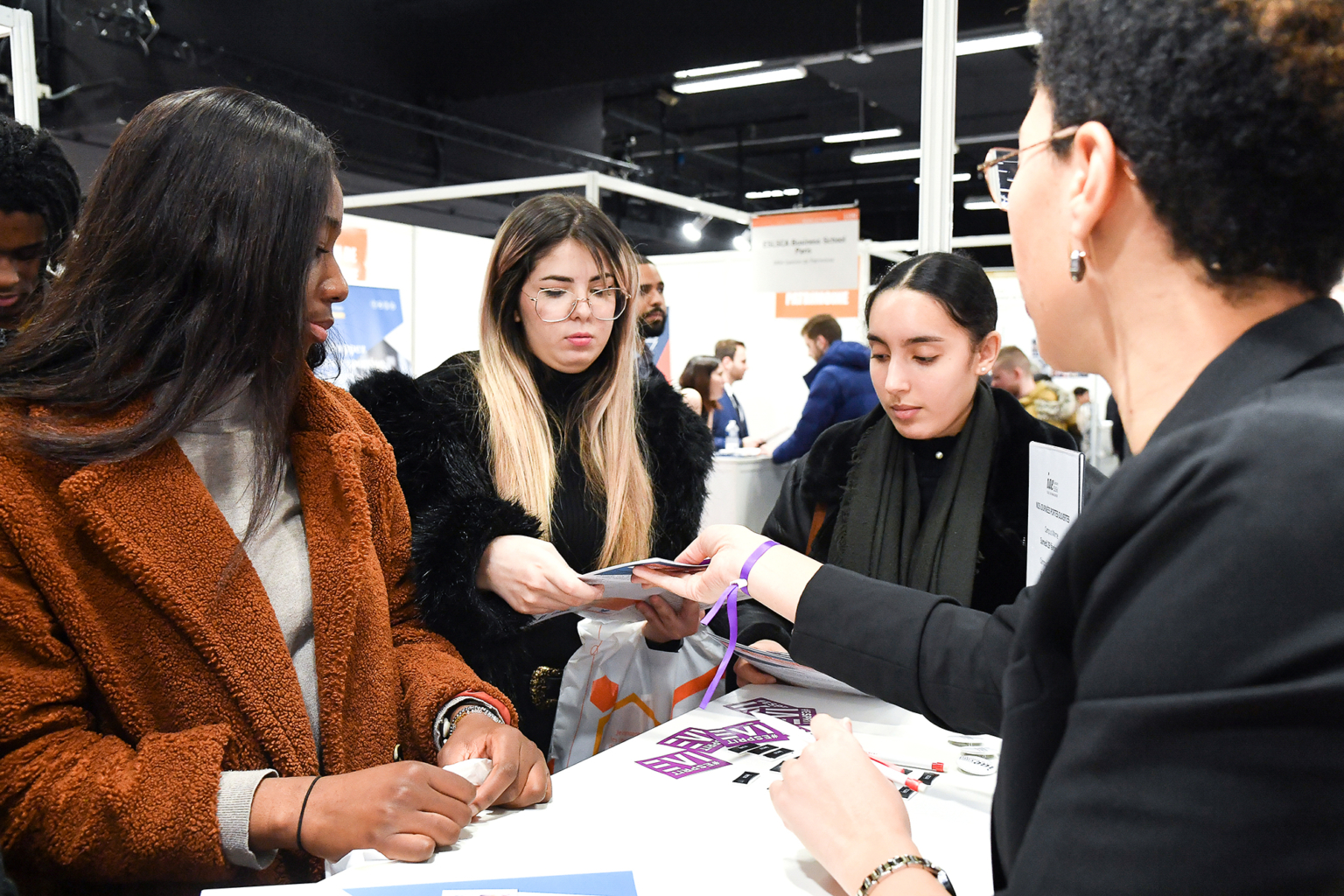 Photo illustrant la distribution de plaquettes d’information lors d’un salon d’étudiants